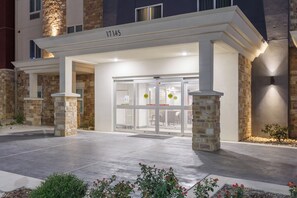 A hotel entrance with a stone facade, numbered 17145, and a glass door entrance. - Candlewood Suites San Antonio - Schertz (Schertz)