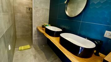 Un baño moderno con dos lavamanos, un mueble de tocador de madera, un espejo y zona de ducha.