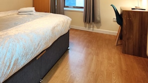 A hotel room with a bed, a desk, a television, and a window with curtains. - Liverpool Stays - City Centre Rooms (Liverpool)