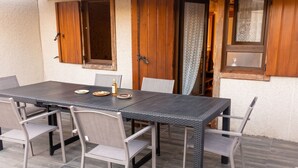 A dining table with chairs, a bottle, and plates set for a meal.