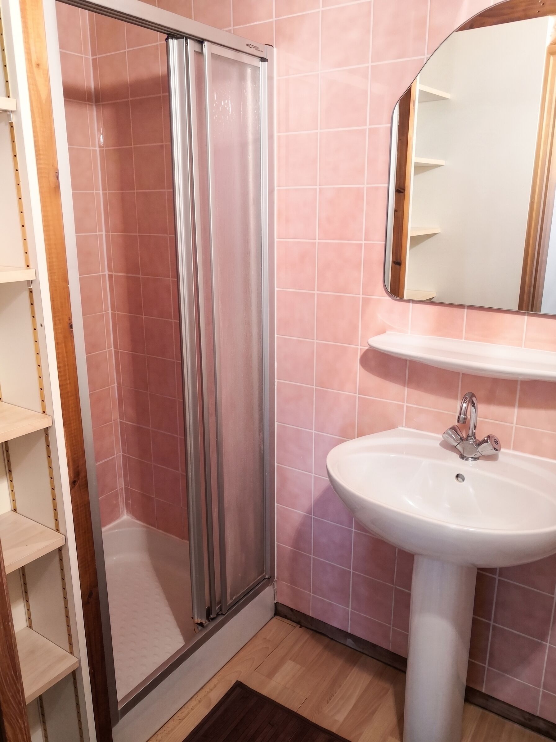 Ein Badezimmer mit Dusche, Waschbecken und Spiegel.