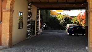 A cobblestone alleyway leading to a building with a brick archway and a sign that reads "RECEPTION".