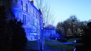 Un bâtiment doté d’une grande fenêtre et d’un arbre devant.