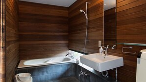 Ein modernes Badezimmer mit einer freistehenden Badewanne, einem weißen Waschbecken und einer Duschkabine aus Glas.