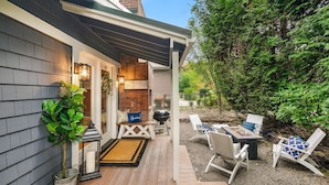 A wooden deck with outdoor furniture, a grill, and a welcome sign.