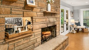 A stone fireplace with a coffee bar setup, including a coffee maker, mug, and sign.