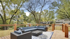 Een houten terras met een modulaire bank en een gekleurd tapijt.