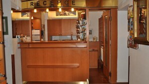 A reception area with a wooden counter, a sign above it reading "RECEPCE," and a wall-mounted display with various items. - City Centre (Prague)
