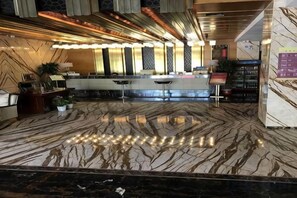 A hotel lobby with a marble floor, reception desk, and seating area. - Jinshi Building Hotel(Yuegezhuang Bridge, Beijing West Railway Station) (Beijing)