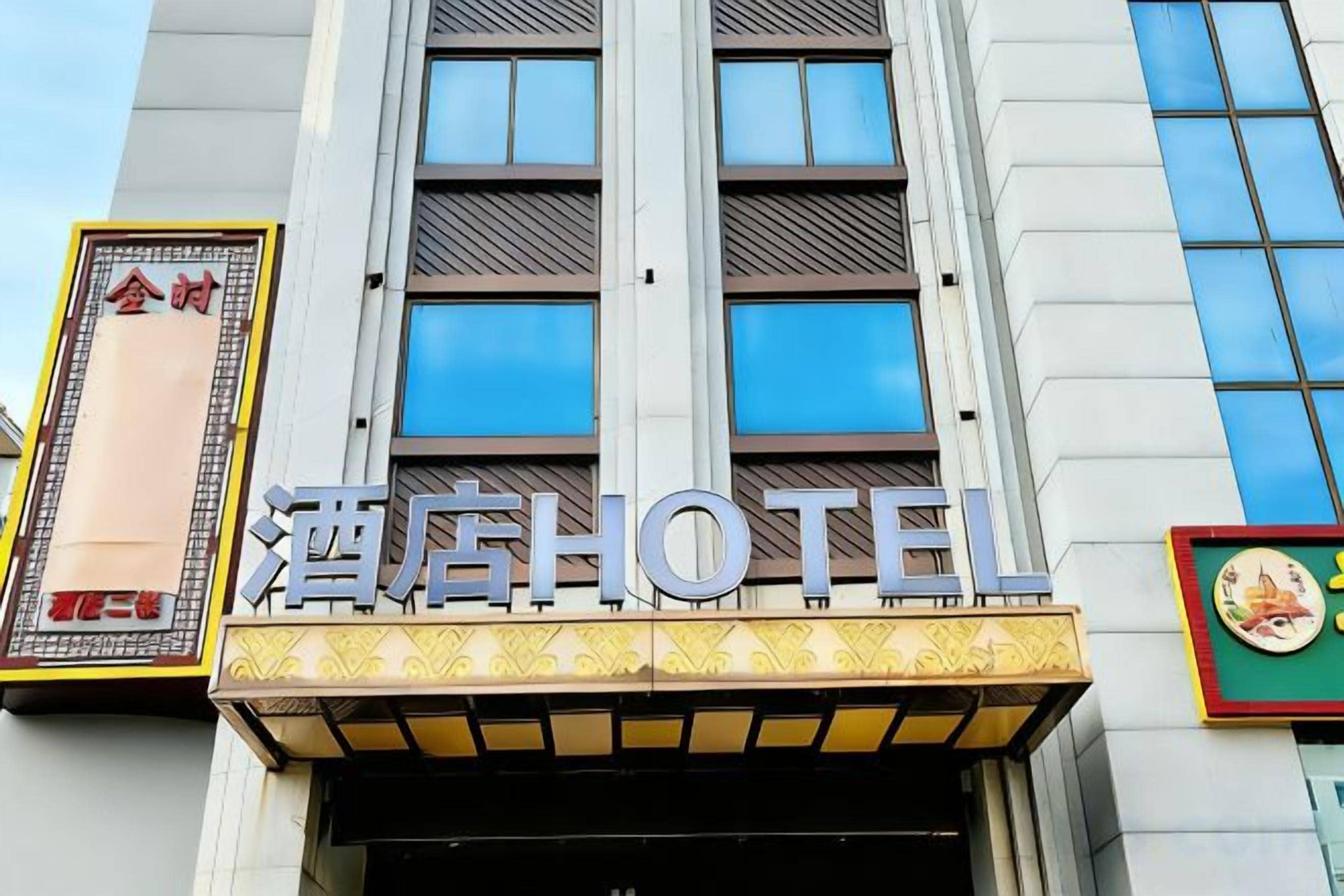 A hotel entrance with a sign that reads 'HOTEL' and a large window above the entrance.