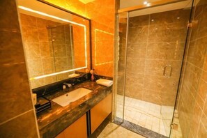 A modern bathroom with a glass-enclosed shower, a large mirror, and a marble countertop. - Jinshi Building Hotel（Yuegezhuang Bridge, Beijing West Railway Station） (Beijing)