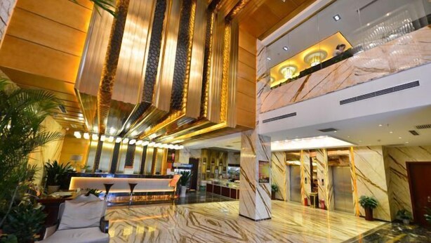 Um hall amplo com balcão de recepção, área de estar e piso de mármore.