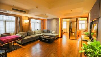 A modern living room with a sectional sofa, a coffee table, and a dining area with a table and chairs.