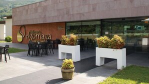 L’extérieur d’un hôtel moderne, avec un espace de détente en plein air et des plantes en pot.
