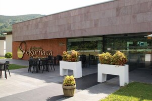 Exterior moderno de hotel con asientos exteriores y plantas en macetas.