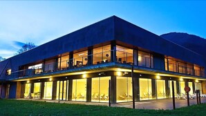 Un bâtiment moderne doté de grandes fenêtres en verre et d’un toit plat.
