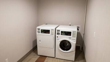 A laundry room with two stacked washing machines and a dryer.