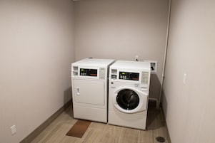 A laundry room with two stacked washing machines and a dryer.