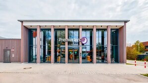 A Premier Inn hotel with a modern facade, large glass windows, and a clear entrance. - Premier Inn Munich Airport Sud Hotel (Hallbergmoos)