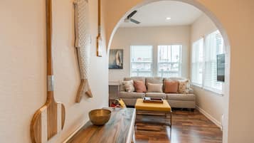 A hallway with a wooden bench, a decorative bowl, and a wall-mounted rack.