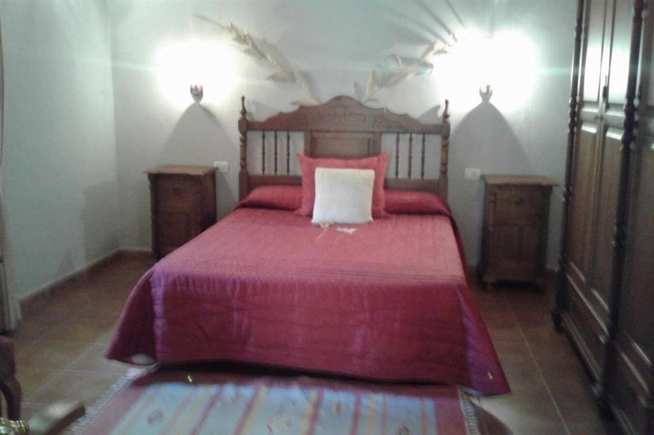 Un dormitorio con una cama de madera, dos mesitas de noche y un techo decorativo.