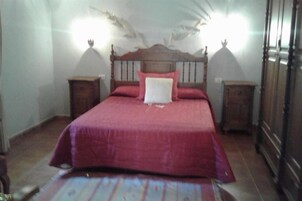 Un dormitorio con una cama de madera, dos mesitas de noche y un techo decorativo.
