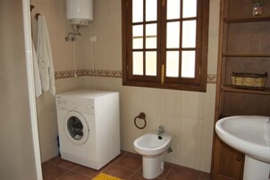 Un baño pequeño con lavadora, bidé y lavamanos.