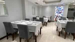 A dining area with tables set for service, a large window, and a modern interior design. - Hotel Des Beaux Arts (Algiers)