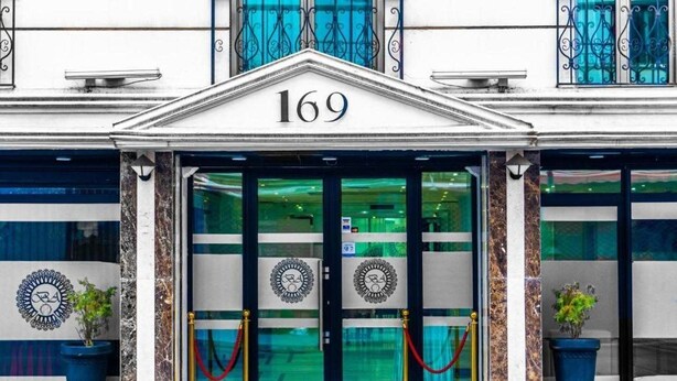 A building with the number 169 on the facade, featuring a grand entrance with double doors and a decorative emblem above. - Hotel Des Beaux Arts (Algiers)