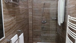 A shower with a glass door, a towel rack, and a showerhead. - Costa Ayaa Appart Hotel (Algiers)