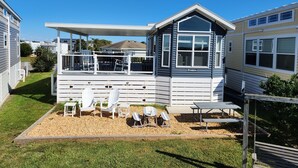 Une maison moderne de plain-pied dotée d’un patio couvert, d’un espace salon extérieur et d’une petite terrasse.