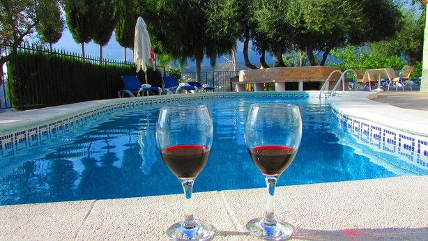 A swimming pool with two glasses of red wine on the edge. - Parador de los Olivos Sayalonga by Ruralidays (Málaga)