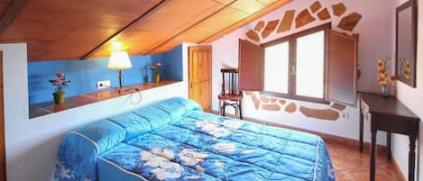 A bedroom with a bed, a desk, a chair, a lamp, and a window.