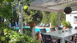 A covered outdoor area with a pool, lounge chairs, and a table with chairs. - Finca Mi Hogar Málaga - Churriana by Ruralidays (Málaga)