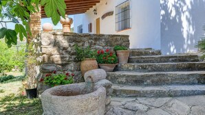 A stone staircase leading to a white building with a stone wall and a water feature. - La Monja Antequera - La Higuera by Ruralidays (Málaga)