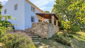 A white building with a stone staircase leading to a wooden pergola. - La Monja Antequera - La Higuera by Ruralidays (Málaga)