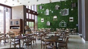 A restaurant with a green wall, wooden furniture, and hanging lights. - 4 B/R Villa, Free Parking & Free Wi-Fi, Near Disney Family Friendly (Kissimmee)