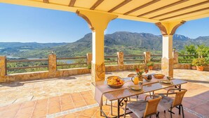 A terrace with a table set for breakfast, stone flooring, and a scenic mountain view. - Vistahermosa del Gastor by Ruralidays (Cádiz)