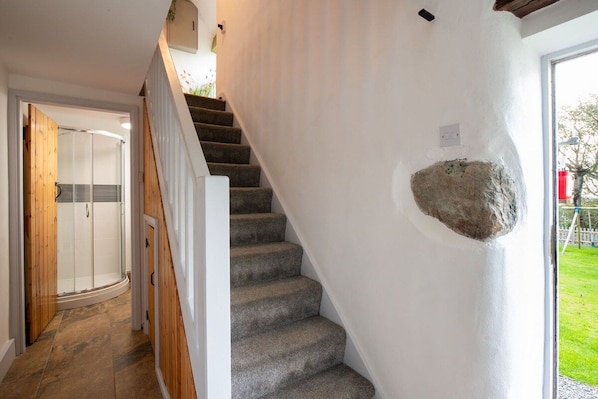 A staircase with carpeted steps leading to a room with a glass door.
