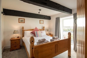 Master double bedroom with exposed wooden beams in Hill Top 1, pet-friendly barn conversion sleeping six in Caergeiliog, Anglesey - Hill Top: 5 bedroom Anglesey holiday barn conversion (Caergeiliog)