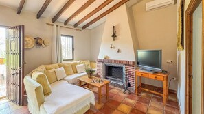 A cozy living room with a sofa, a fireplace, a television, and a chessboard. - Casa Madrona Periana by Ruralidays (Málaga)
