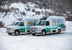 Two white recreational vehicles parked on a snowy surface with a mountainous background. - Ski-In/Out to Stampede Run | Fireplace & Views (Steamboat Springs)