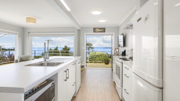 A modern kitchen with a large island, built-in appliances, and a view of the outdoors. - I See The Lake - Omori Holiday Home (Omori)
