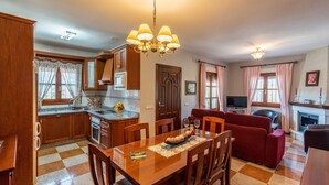 A spacious living area with a dining table, red sofa, and a fireplace. - Villa Mi Paraíso Torrox by Ruralidays (Málaga)