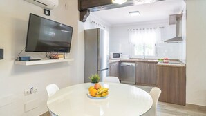 Et moderne køkken med indbygget mikroovn, rustfrie hårde hvidevarer og en hvid bordplade.