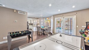 A spacious living area with a foosball table, a pool table, and a dining area with a table and chairs. - Modern & Cozy | 13min to Strip, ♛Royal Beds, Pool (Henderson)