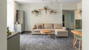 A modern living room with a sofa, a coffee table, and a dining area with a table and chairs. - The dreamer house design (Roma)