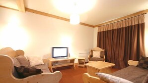 Una camera accogliente con un letto di legno, una scrivania con un computer, una sedia e una finestra con tende.