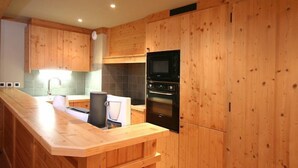 Una cucina moderna con mobili in legno, un forno a microonde integrato e un forno.