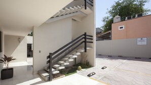 A modern building with a staircase, outdoor seating area, and a parking lot. - Apartment with GREAT LOCATION, 1 block from the boardwalk (La Paz)